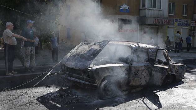 Obyvatelé Doněcku obhlížejí automobil zničený údajně ukrajinskou dělostřelbou (28. srpna 2014)