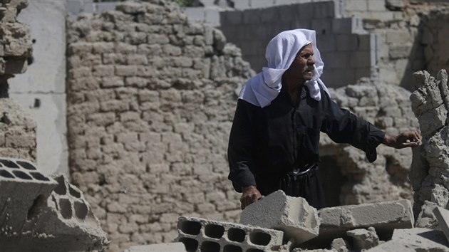 Muž se zkoumá poničený dům v Dúmě, ležícím na východě od Damašku (24. srpna 2014).