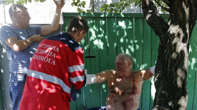 Zdravotnci pomhaj mui z Doncku, kter utrpl zrann pi ostelovn msta (26. srpna 2014).