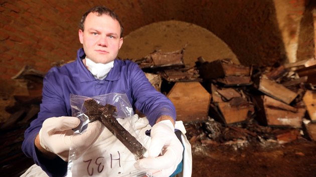 Archeolog Michal Bernek ukazuje jeden z bnjch nlez - devn kek.