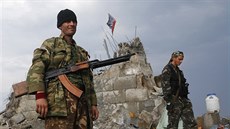 Proruští separatisté se procházejí u poničeného pomníku na výšině-Savur Mohyla,...