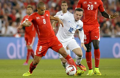 Kapitn anglick reprezentace Wayne Rooney atakuje vcarskho fotbalistu