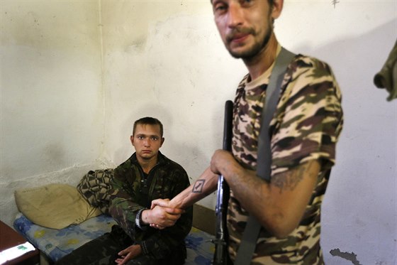 Povstalec si podává ruku se zajatým ukrajinským vojákem ve vesnici Starobeeve...