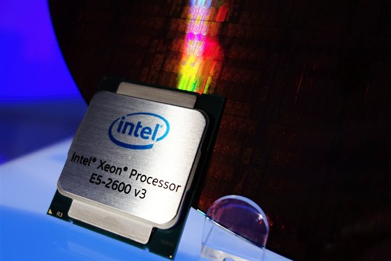 Nový serverový procesor Intel Xeon E5-2600 v3 před křemíkovým waferem, ze kterého je řezán.