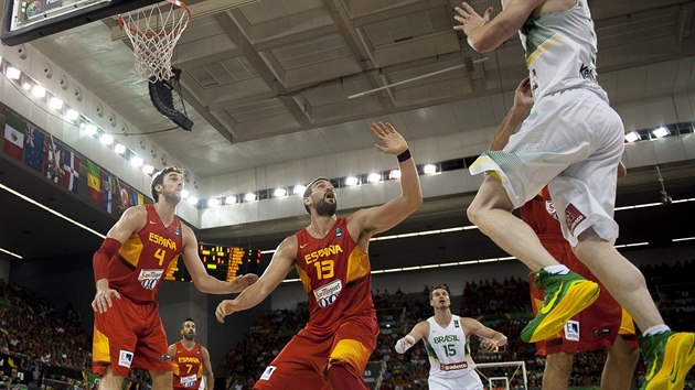 Brazilsk rozehrva Marcelinho Huertas (v blm) zakonuje na panlsk ko pes bratrskou dvojici Marc Gasol (13) a Pau Gasol (4).