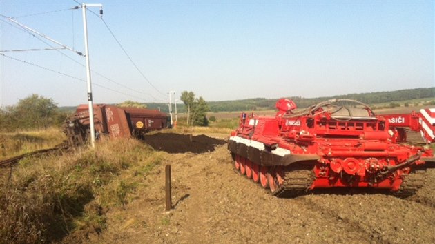 Speciln tank se pod dohledem hasi i pracovnk Sprvy eleznin dopravn cesty chyst na vyprotn vykolejenho nkladnho vlaku u Pevova (17. z 2014).
