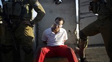 Izrael�tí vojáci s Palestincem, kterého zadr�eli b�hem protest� proti nové...