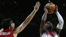 Americký basketbalista Kyrie Irving (u míe) proniká k srbskému koi kolem...