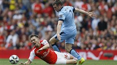 NA ZEMI. Aaron Ramsey (vlevo) z Arsenalu padá na zem po souboji s Jamesem...