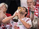 Kapitán polských volejbalist Michal Winiarski líbá trofej pro mistry svta.