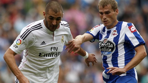 Alex Bergantinos z La Coruni (vpravo) chce vzt m Karimu Benzemovi z Realu Madrid.
