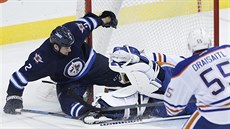 Leon Draisaitl z Edmontonu sleduje stet svého brankáe Tylera Rimmera s...