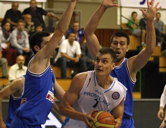 Prostjovský basketbalista Radek Neas se snaí prosadit proti bránícím hrám ...