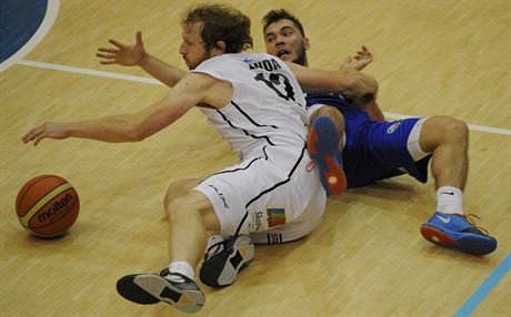 Dínský basketbalista Robert Landa (vlevo) bojuje o mí s ostravským Adamem...