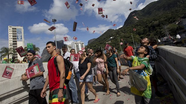 Dti v jedn z chudinskch tvrt v brazilsk metropoli Rio de Janeiro vyhazuj do vzduchu ped kolou propagan lstky kandidt (5. jna 2014).
