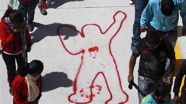 Lidé na demonstraci v mexickém městě Chilpancingo kráčejí kolem siluety zabitého studenta, kterou nakreslili na zem.