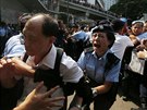 Policistka se snaí zastavit rozzueného odprce prodemokratických aktivist v...