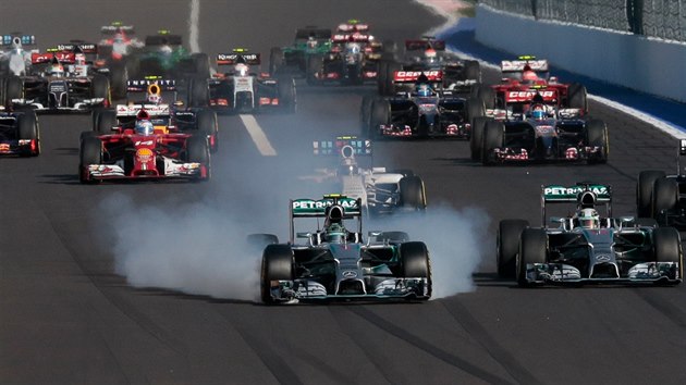 Nico Rosberg si práv nií pneumatiky, vedle nj je Lewis Hamilton.