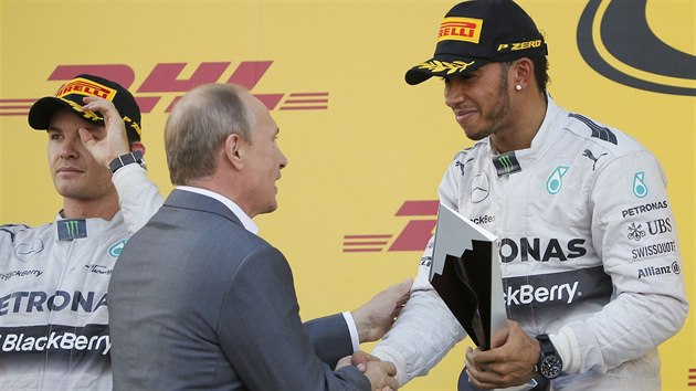 GRATULUJI. Rusk prezident Vladimir Putin gratuluje Lewisovi Hamiltonovi k vtzstv ve Velk cen Ruska. Vlevo je Nico Rosberg.