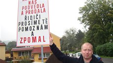 Jaromír Már mlad�í chce cedulí upozornit na spor o kamiony, který obyvatelé...