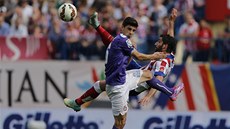 VE VZDUCHU. Raul García z Atlétika Madrid akrobaticky odkopává mí�, tísní ho