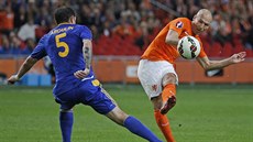 Arjen Robben z Nizozemska pálí, brání ho Renat Abdulin z Kazachstánu.