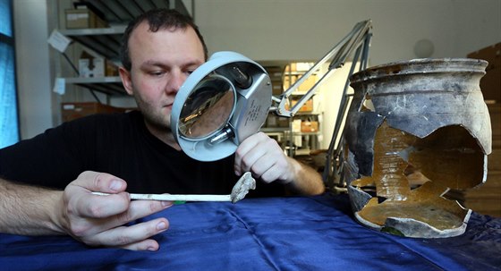 Archeolog Michal Beránek si prohlíí keramickou dýmku nalezenou v jímce pi...