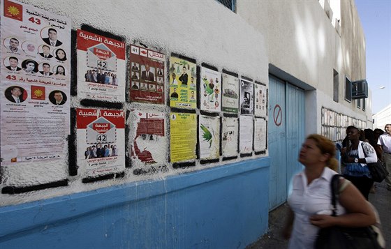 Lidé v Tunisu se dívají na pedvolební plakáty (22. íjna 2014).