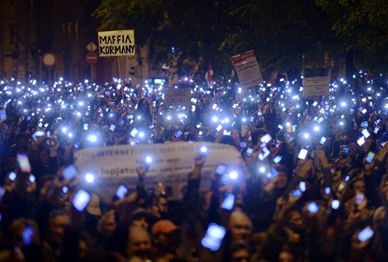 Tisíce demonstrantů drží mobilní telefony na protest proti plánované...