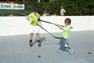 Děti trénují s hokejkami.
