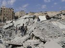 Civilisté zkoumají místo v Aleppu, kam podle aktivist dopadla raketa jednotek...