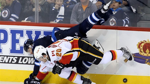 SYNCHRONIZOVAN PADN. Blake Wheeler z Winnipegu a Curtis Glencross z Calgary (ve svtlm).