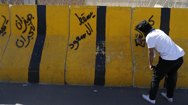 Šíitský protestující sprejuje nápisy na záterasy u ambasády Saúdské Arábie v Sanaa během protestů proti rozsudku smrti šejka Nimr al-Nimra (18. října 2014).