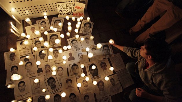 Lid zapaluj svky u portrt 43 student, kte zmizeli 26. z (Monterrey, 23. jna 2014).