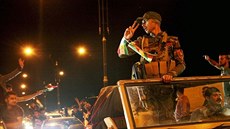 Lidé mávají iráckým pešmergům, kteří vyrazili do boje do syrského Kobani (28....