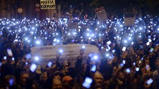 Tisíce demonstrant drí mobilní telefony na protest proti plánované...