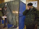 Neoznaený ozbrojenec hlídkuje ve volební místnosti v Doncku (2. listopadu...