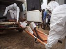 Zdravotníci ve mst Kenema v Siee Leone peváejí na izolaní jednotku mue,...