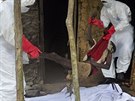 Zdravotníci vynáejí z domu na pedmstí liberijské Monrovie mue s podezením...