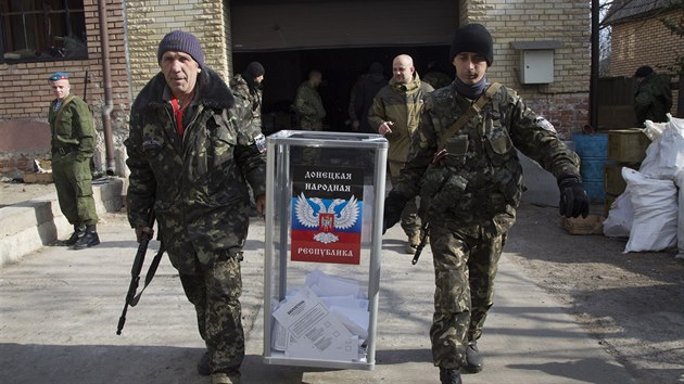 Ozbrojenci přenášejí volební urnu k provizornímu hlasovacímu místo nedaleko doněckého letiště, o něž týdny svádějí sepratisté boje s ukrajinskou armádou (2. listopadu 2014).