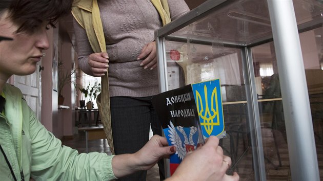 Členky volební komise v Doněcku přelepují na volební urně ukrajinský státní znak nálepkou se znakem Doněcké lidové republiky (31. října 2014).