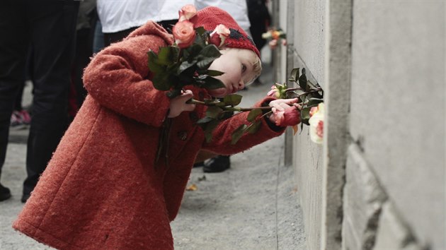 Lid ozdobili pamtnk Berlnsk zdi pi 25. vro jejho pdu kvtinami (Berln, 9. listopadu 2014).