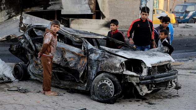 Dti si prohlej auto, kter zcela zniila nastraen bomba (Bagdd, 9. listopadu 2014).