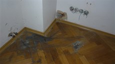 Ve v�ech místnostech bytu z�staly jen díry po vytrhaných zásuvkách.
