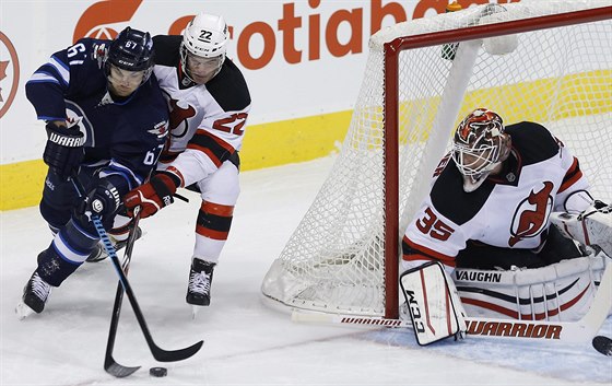 Michael Frolík (vlevo) z Winnipegu se tlaí ped branku New Jersey.