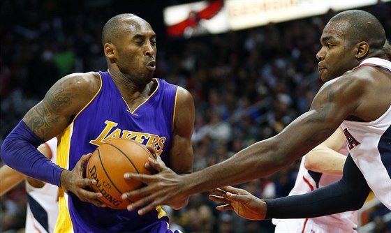 Kobe Bryant (vlevo) z LA Lakers útoí na ko Atlanty kolem Paula Millsapa.