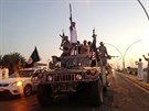 Islamisté projíždějí ulicemi Mosulu během improvizované vojenské přehlídky.