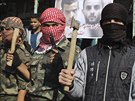 V Rafáhu maskovaní palestintí bojovníci se sekerami, noi a zbranmi oslavují...