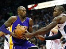 Kobe Bryant (vlevo) z LA Lakers útoí na ko Atlanty kolem Paula Millsapa.