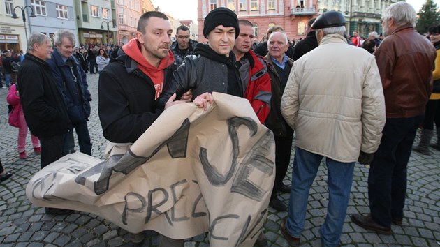 Policisté v civilu odvádějí stranou dva mladé lidi, kteří na mítinku Miloše Zemana v Krnově nesli transparent Stydím se za svého prezidenta. (11. listopadu 2014)